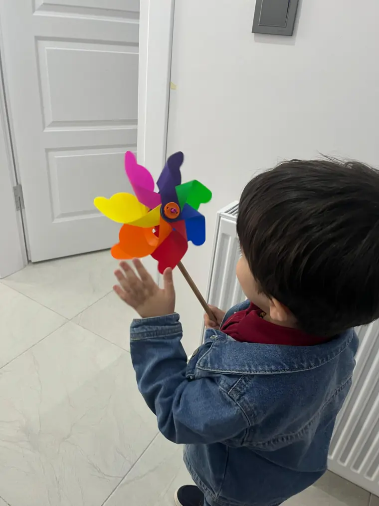 Rüzgar gülüyle oynayan bir çocuk